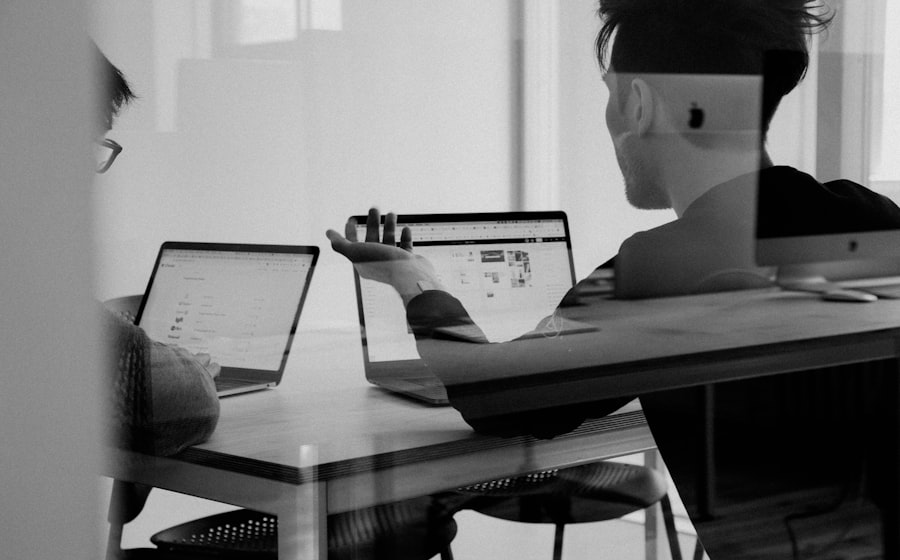 Two colleagues reviewing customer retention figures on a laptop together